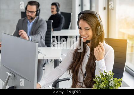 Freundliche Helpline-Mitarbeiterin mit Headset im Callcenter. Stockfoto