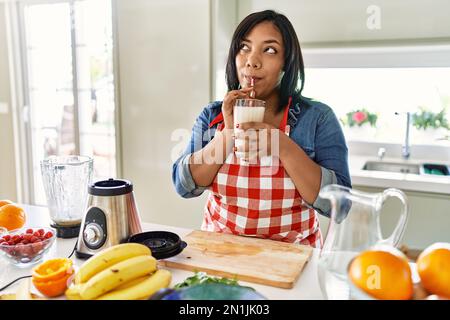 Hispanische Brünette Frau trinkt frischen Obst-Smoothie in der Küche Stockfoto