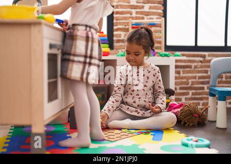 Zwei Kinder spielen mit Spielküche und Mathematik-Puzzle-Spiel im Kindergarten Stockfoto