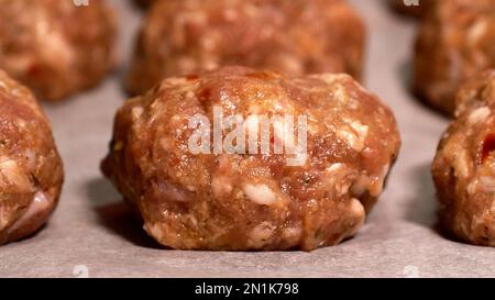 Frisches rohes Rindfleisch, Lamm, Fleischbällchen in einer Reihe auf dem Tisch. Halbfertiges rohes Fleisch, fertig für die Zubereitung. Lebensmittelhintergrund. Schließen. Stockfoto