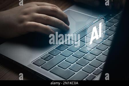 Frau, die einen Laptop mit KI-Hologramm-Schnittstelle benutzt. Das Konzept der künstlichen Intelligenz nutzt Analysen, Automatisierung und autonomes Gehirn. Stockfoto
