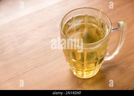 Selektive Fokussierung eines Glases Tee mit Teebeutel auf Holzhintergrund. Stockfoto