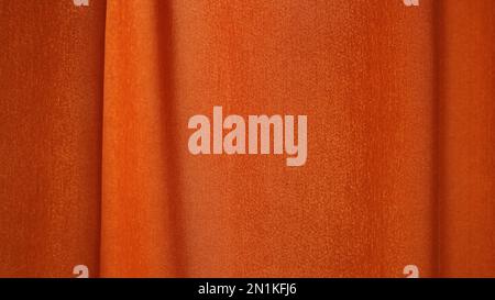 Einfarbiger, orangefarbener Stoffvorhang mit einer glatten Welle im Relief, durchgehender Rahmen, Baumwolle- oder Leinenmaterial mit einer flachen Oberfläche und einer leichten Biegung im Plisseedetail Stockfoto