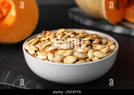 Rohe Kürbiskerne auf schwarzem Tisch, Nahaufnahme Stockfoto