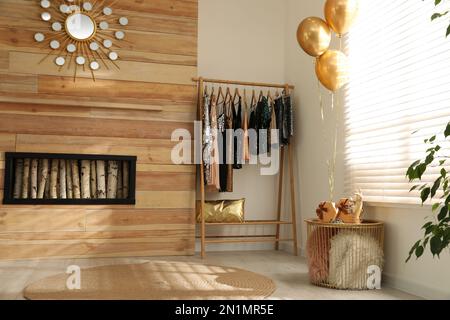 Gestell mit stilvoller Damenbekleidung im Zimmer. Innendesign Stockfoto