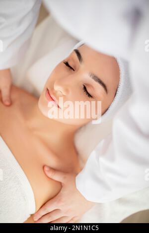 Spa-Behandlung. Wunderschöne Indische Frau, Die Schultermassage Von Einem Professionellen Masseur Bekommt Stockfoto