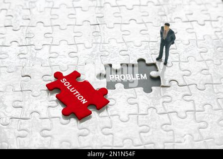Selektiver Fokus eines Miniaturgeschäfts und ein leerer Raum mit Puzzle, das mit Problem geschrieben wurde, und ein Puzzlestück, das mit Lösung geschrieben wurde. Stockfoto