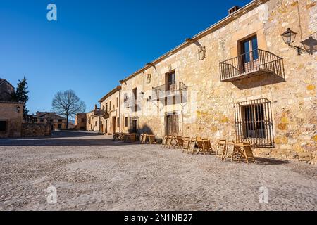 Alte Steingebäude mit gegrillten Balkonen und Holztüren in der mittelalterlichen Stadt Pedraza, Kastilien und Leon, Spanien. Stockfoto