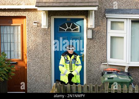 HERAUSGEBER HINWEIS: Hausnummer verpixelt von PA Media Picture Desk Ein Polizist steht vor einem Grundstück in Walpole Road, Huddersfield, West Yorkshire, wo eine Frau wegen Mordverdachts verhaftet wurde, nachdem vier Personen, darunter drei Kinder, schwer verletzt aufgefunden wurden. Die Beamten wurden gegen 8am Uhr zu der Adresse gerufen, nachdem sie einen Bericht des Rettungsdienstes erhalten hatten. Foto: Montag, 6. Februar 2023. Stockfoto