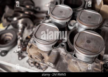 Viele Werkzeuge und Kfz-Ersatzteile in einer Autoreparaturwerkstatt. Autoteile für Reparaturen. Gebrauchtes Fahrzeugteil zum Recycling in der Schrottgarage. Stockfoto