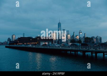 Brücke mit Autos und nächtliche Stadtlandschaft mit Wolkenkratzern in New York City, Stockbild Stockfoto