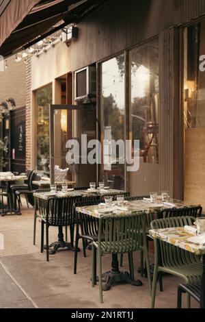 Tafelgeschirr auf Tischen des Cafés im Freien an der Straße in New York City, Stockbild Stockfoto