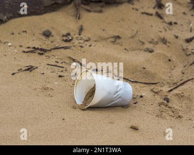 Plastikbecher wurde am Strand zurückgelassen und von sorglosen Leuten weggeworfen Stockfoto