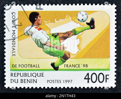 Von Benin gedruckte Briefmarke für stornierte Porto, die den Fußballspieler zeigt, der die FIFA-Weltmeisterschaft 98 in Frankreich um 1996 bewirbt. Stockfoto