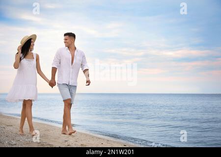 Schönes Paar, das am Strand spaziert. Platz für Text Stockfoto