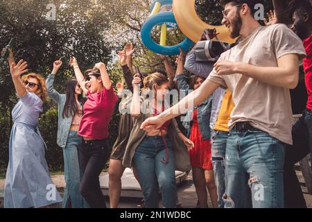 Fröhliche, multiethnische Menschen tanzen auf der Spring Break Party, hören Musik aus einer alten Boombox und haben Spaß zusammen Stockfoto
