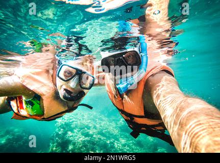Aktives Seniorenpaar, das unter Wasser Selfie auf einem tropischen Meeresausflug mit Wasserkamera machte - Bootsausflug Schnorcheln in exotischen Szenarien - Rentner
