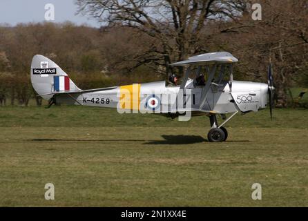 Ein De Havilland DH-82A Tiger Moth, der 500 Jahre Royal Mail feiert, startet vom Flugplatz Headcorn in England Stockfoto