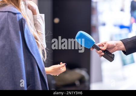 Pressejournalistin macht Medieninterview mit einer nicht wiedererkennbaren weiblichen Person Stockfoto