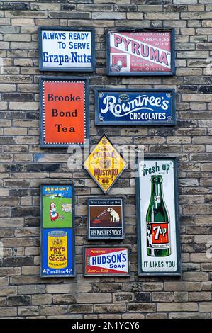 Eine Sammlung von emaillierten Schildern an einer Wand im Bradford Industrial Museum, Moorside Mills, Eccleshill, Bradford. Stockfoto