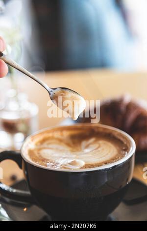 Löffel zum Rühren von Kaffee in einem Hipster Coffee Shop. Entspannte und stilvolle Atmosphäre. Barista Stockfoto