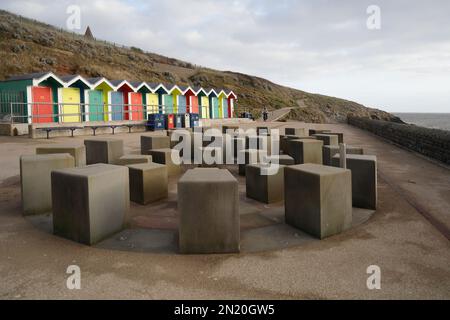 Farbenfrohe Strandhütten und Ammonit Wasserspiel, Promenade, Barry Island, South Wales, aufgenommen im Januar 2023. Im Winter. Ein Sprühnebel. Zyl Stockfoto