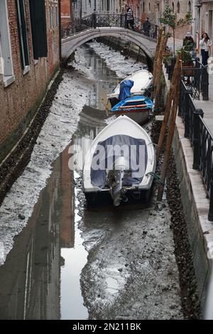 Boote liegen auf dem Boden des trockenen Wasserwegs, in St. Bezirk Markus, während einer ungewöhnlich niedrigen Flut in Venedig, Italien, 06. Februar 2023. © Andrea MEROLA Stockfoto