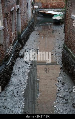 Boote liegen auf dem Boden des trockenen Wasserwegs, in St. Bezirk Markus, während einer ungewöhnlich niedrigen Flut in Venedig, Italien, 06. Februar 2023. © Andrea MEROLA Stockfoto