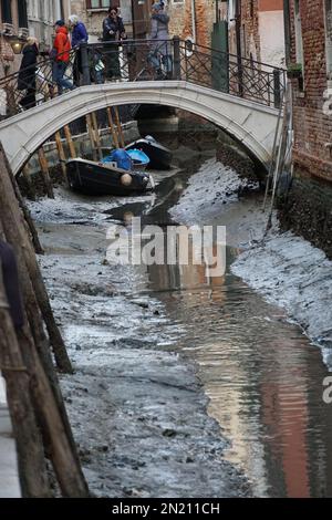 Boote liegen auf dem Boden des trockenen Wasserwegs, in St. Bezirk Markus, während einer ungewöhnlich niedrigen Flut in Venedig, Italien, 06. Februar 2023. © Andrea MEROLA Stockfoto