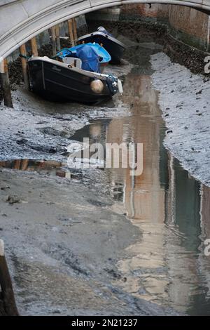 Boote liegen auf dem Boden des trockenen Wasserwegs, in St. Bezirk Markus, während einer ungewöhnlich niedrigen Flut in Venedig, Italien, 06. Februar 2023. © Andrea MEROLA Stockfoto