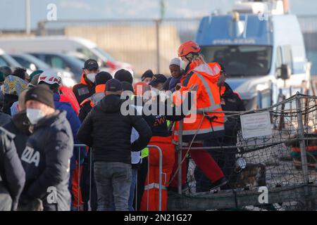 Neapel, Italien. 06. Februar 2023. Den Menschen wird geholfen, das Rettungsschiff Sea-Eye 4 zu verlassen, nachdem es mit 106 Migranten an Bord im Hafen von Neapel angedockt hat. Das Schiff sollte im Hafen von Pesaro anlegen, aber es wurde schließlich genehmigt, seine Passagiere in Neapel aufgrund rauer Seebedingungen aussteigen zu lassen. Kredit: Unabhängige Fotoagentur/Alamy Live News Stockfoto