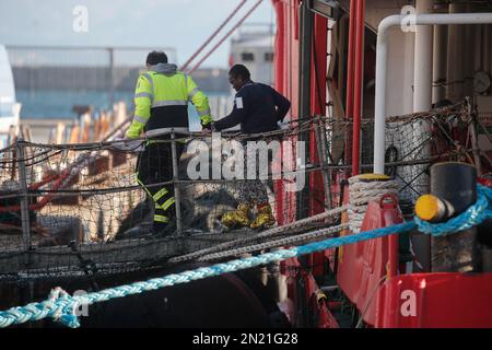 Neapel, Italien. 06. Februar 2023. Den Menschen wird geholfen, das Rettungsschiff Sea-Eye 4 zu verlassen, nachdem es mit 106 Migranten an Bord im Hafen von Neapel angedockt hat. Das Schiff sollte im Hafen von Pesaro anlegen, aber es wurde schließlich genehmigt, seine Passagiere in Neapel aufgrund rauer Seebedingungen aussteigen zu lassen. Kredit: Unabhängige Fotoagentur/Alamy Live News Stockfoto