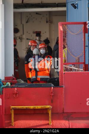 Neapel, Italien. 06. Februar 2023. Den Menschen wird geholfen, das Rettungsschiff Sea-Eye 4 zu verlassen, nachdem es mit 106 Migranten an Bord im Hafen von Neapel angedockt hat. Das Schiff sollte im Hafen von Pesaro anlegen, aber es wurde schließlich genehmigt, seine Passagiere in Neapel aufgrund rauer Seebedingungen aussteigen zu lassen. Kredit: Unabhängige Fotoagentur/Alamy Live News Stockfoto