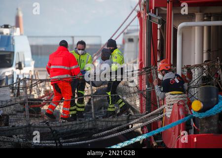 Neapel, Italien. 06. Februar 2023. Den Menschen wird geholfen, das Rettungsschiff Sea-Eye 4 zu verlassen, nachdem es mit 106 Migranten an Bord im Hafen von Neapel angedockt hat. Das Schiff sollte im Hafen von Pesaro anlegen, aber es wurde schließlich genehmigt, seine Passagiere in Neapel aufgrund rauer Seebedingungen aussteigen zu lassen. Kredit: Unabhängige Fotoagentur/Alamy Live News Stockfoto