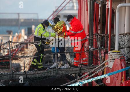 Neapel, Italien. 06. Februar 2023. Den Menschen wird geholfen, das Rettungsschiff Sea-Eye 4 zu verlassen, nachdem es mit 106 Migranten an Bord im Hafen von Neapel angedockt hat. Das Schiff sollte im Hafen von Pesaro anlegen, aber es wurde schließlich genehmigt, seine Passagiere in Neapel aufgrund rauer Seebedingungen aussteigen zu lassen. Kredit: Unabhängige Fotoagentur/Alamy Live News Stockfoto