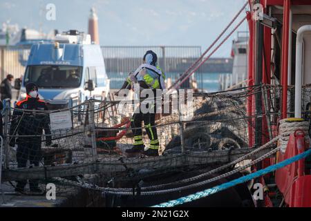 Neapel, Italien. 06. Februar 2023. Den Menschen wird geholfen, das Rettungsschiff Sea-Eye 4 zu verlassen, nachdem es mit 106 Migranten an Bord im Hafen von Neapel angedockt hat. Das Schiff sollte im Hafen von Pesaro anlegen, aber es wurde schließlich genehmigt, seine Passagiere in Neapel aufgrund rauer Seebedingungen aussteigen zu lassen. Kredit: Unabhängige Fotoagentur/Alamy Live News Stockfoto