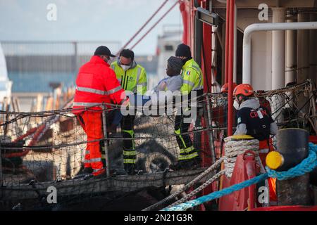 Neapel, Italien. 06. Februar 2023. Den Menschen wird geholfen, das Rettungsschiff Sea-Eye 4 zu verlassen, nachdem es mit 106 Migranten an Bord im Hafen von Neapel angedockt hat. Das Schiff sollte im Hafen von Pesaro anlegen, aber es wurde schließlich genehmigt, seine Passagiere in Neapel aufgrund rauer Seebedingungen aussteigen zu lassen. Kredit: Unabhängige Fotoagentur/Alamy Live News Stockfoto