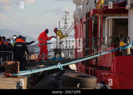 Neapel, Italien. 06. Februar 2023. Den Menschen wird geholfen, das Rettungsschiff Sea-Eye 4 zu verlassen, nachdem es mit 106 Migranten an Bord im Hafen von Neapel angedockt hat. Das Schiff sollte im Hafen von Pesaro anlegen, aber es wurde schließlich genehmigt, seine Passagiere in Neapel aufgrund rauer Seebedingungen aussteigen zu lassen. Kredit: Unabhängige Fotoagentur/Alamy Live News Stockfoto