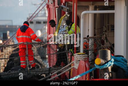 Neapel, Italien. 06. Februar 2023. Den Menschen wird geholfen, das Rettungsschiff Sea-Eye 4 zu verlassen, nachdem es mit 106 Migranten an Bord im Hafen von Neapel angedockt hat. Das Schiff sollte im Hafen von Pesaro anlegen, aber es wurde schließlich genehmigt, seine Passagiere in Neapel aufgrund rauer Seebedingungen aussteigen zu lassen. Kredit: Unabhängige Fotoagentur/Alamy Live News Stockfoto