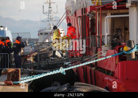 Neapel, Italien. 06. Februar 2023. Den Menschen wird geholfen, das Rettungsschiff Sea-Eye 4 zu verlassen, nachdem es mit 106 Migranten an Bord im Hafen von Neapel angedockt hat. Das Schiff sollte im Hafen von Pesaro anlegen, aber es wurde schließlich genehmigt, seine Passagiere in Neapel aufgrund rauer Seebedingungen aussteigen zu lassen. Kredit: Unabhängige Fotoagentur/Alamy Live News Stockfoto