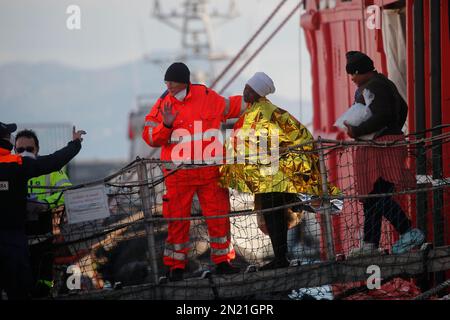 Neapel, Italien. 06. Februar 2023. Den Menschen wird geholfen, das Rettungsschiff Sea-Eye 4 zu verlassen, nachdem es mit 106 Migranten an Bord im Hafen von Neapel angedockt hat. Das Schiff sollte im Hafen von Pesaro anlegen, aber es wurde schließlich genehmigt, seine Passagiere in Neapel aufgrund rauer Seebedingungen aussteigen zu lassen. Kredit: Unabhängige Fotoagentur/Alamy Live News Stockfoto