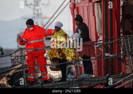 Neapel, Italien. 06. Februar 2023. Den Menschen wird geholfen, das Rettungsschiff Sea-Eye 4 zu verlassen, nachdem es mit 106 Migranten an Bord im Hafen von Neapel angedockt hat. Das Schiff sollte im Hafen von Pesaro anlegen, aber es wurde schließlich genehmigt, seine Passagiere in Neapel aufgrund rauer Seebedingungen aussteigen zu lassen. Kredit: Unabhängige Fotoagentur/Alamy Live News Stockfoto