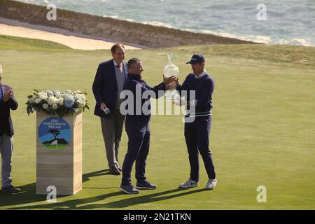 Pebble Beach, Kalifornien, USA. 6. Februar 2023. Justin Rose erhält die Trophäe, nachdem sie den AT&T Pro-am 2023 gewonnen hat. Der Präsident VON AT&T bei Pebble Beach Golf Links überreicht die Trophäe während der letzten Runde des PGA Tour Golfturniers am Montag. Gutschrift: ELJaypix/Alamy Live News Stockfoto