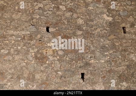 Ziegelwand mit Löchern, Hintergrund aus braunen Steinen Stockfoto