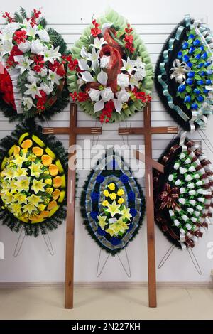 Innenausstattung des Ladens mit Bestattungszubehör. Laden, der Särge, Bestattungskränze und Blumen verkauft. Stockfoto