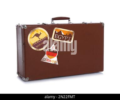Retro-Koffer mit Reiseaufklebern auf weißem Hintergrund Stockfoto