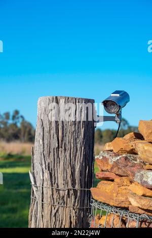 Eine Überwachungskamera, die an einem hölzernen Torpfosten auf einer Farm in West-New-South-Wales, Australien angebracht ist Stockfoto