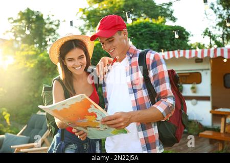 Junge Reisende mit Rucksäcken und Weltkarte planen eine Reise in der Nähe von Wohnmobil Stockfoto