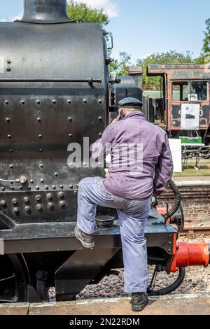 Der Fahrer der BR 'Q' Klasse 0-6-0 Nr. 30541 führt einen Anruf auf dem Handy, Horsted Keynes, Bluebell Railway Stockfoto