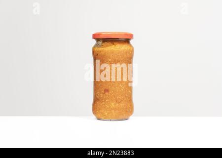 Bild eines Glasbehälters mit Fleischsauce für gekochte Pasta auf einer weißen Oberfläche Stockfoto